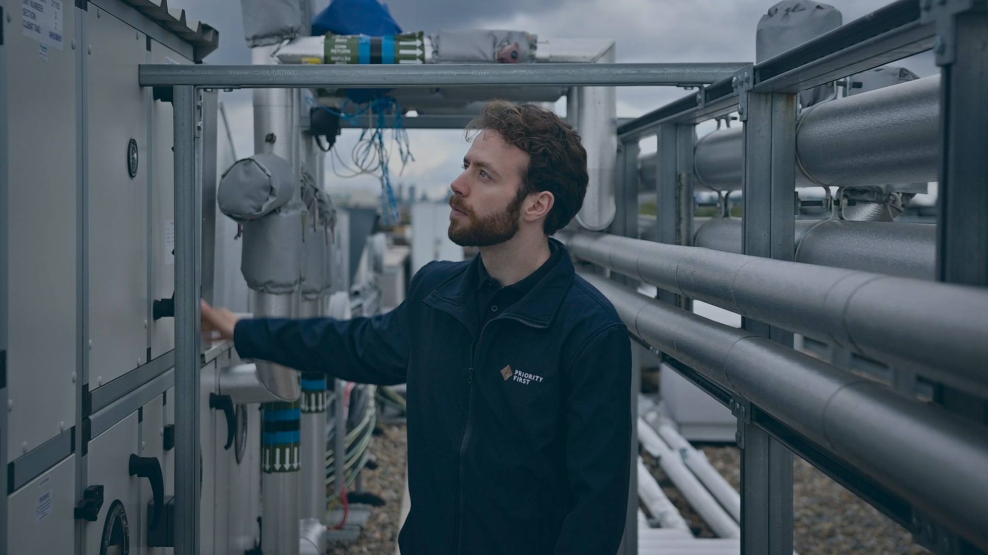 A facilities manager inspecting roof plant against the planned maintenance schedule