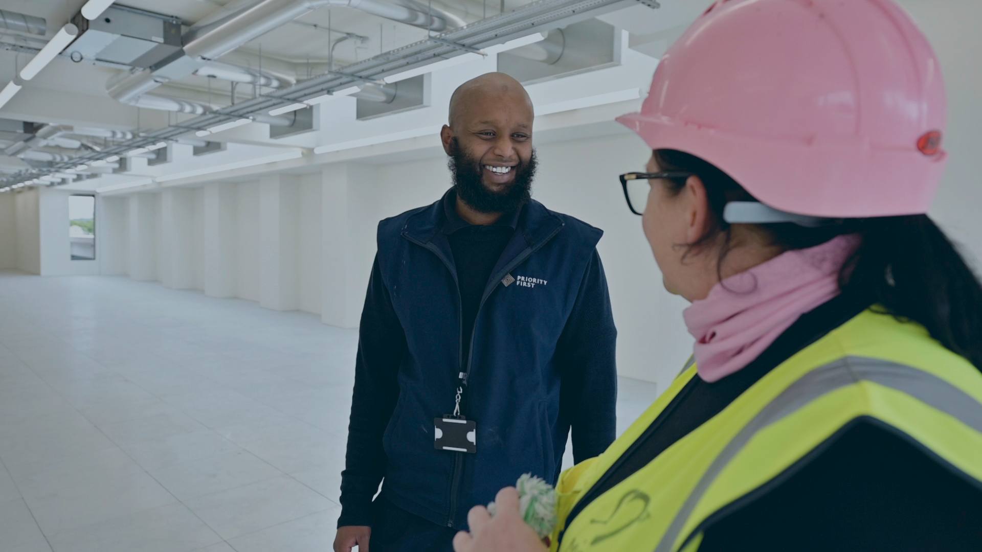 A security officer walking a new-build interior with the site team
